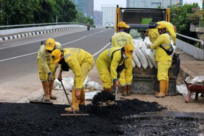 Pekerja Suku Dinas Bina Marga Jakarta Pusat mengaspal jembatan flyover HOS Cokroaminoto yang ambles di Jakarta, Kamis (29/7/2021).