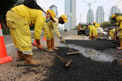 Pekerja Suku Dinas Bina Marga Jakarta Pusat mengaspal jembatan flyover HOS Cokroaminoto yang ambles di Jakarta, Kamis (29/7/2021).