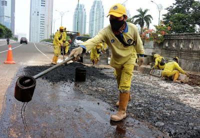 Pekerja Suku Dinas Bina Marga Jakarta Pusat mengaspal jembatan flyover HOS Cokroaminoto yang ambles di Jakarta, Kamis (29/7/2021).