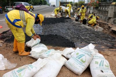 Pekerja Suku Dinas Bina Marga Jakarta Pusat mengaspal jembatan flyover HOS Cokroaminoto yang ambles di Jakarta, Kamis (29/7/2021).