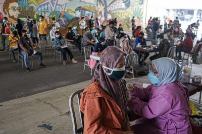 Tenaga kesehatan menyuntikkan vaksin Covid-19 kepada warga di Terowongan Kendal, Jakarta, Jumat (30/7/2021).