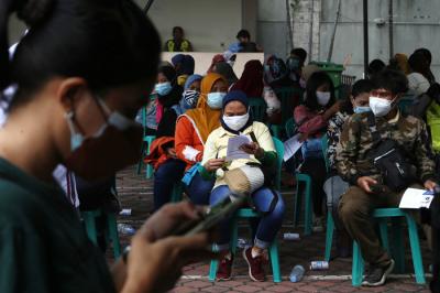 Para pelaku UMKM, pedagang dan masyarakat mengantri untuk mendapatkan vaksin Covid-19 dosis pertama di Sentra Vaksinasi Uniqlo di Surabaya, Jumat (30/7/2021).