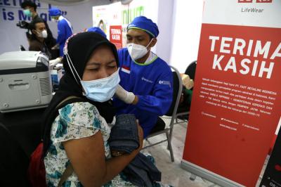Para pelaku UMKM, pedagang dan masyarakat mengantri untuk mendapatkan vaksin Covid-19 dosis pertama di Sentra Vaksinasi Uniqlo di Surabaya, Jumat (30/7/2021).