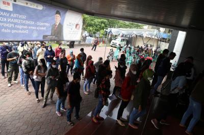 Para pelaku UMKM, pedagang dan masyarakat mengantri untuk mendapatkan vaksin Covid-19 dosis pertama di Sentra Vaksinasi Uniqlo di Surabaya, Jumat (30/7/2021).
