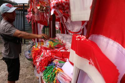 Penjual bendera merah putih dan pernak-pernik HUT Kemerdekaan Republik Indonesia yang Ke-76 merapikan dagangannya di Jalan Matraman, Jakarta (31/7/2021).