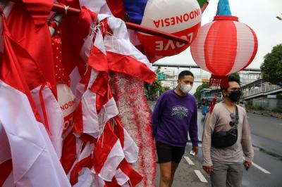 Penjual bendera merah putih dan pernak-pernik HUT Kemerdekaan Republik Indonesia yang Ke-76 merapikan dagangannya di Jalan Matraman, Jakarta (31/7/2021).