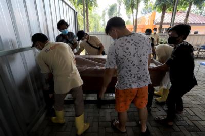 Petugas krematorium bersama keluarga duka mengangkat peti jenazah Covid-19 untuk dikremasi di TPU Tegal Alur, Jakarta, Sabtu (31/7/2021).