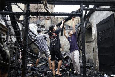 Petugas pemadam kebakaran melakukan pendinginan terhadap bangunan yang terbakar di Jalan Karet Pasar Baru, Karet Tengsin, Jakarta Pusat, Sabtu (31/7/2021).