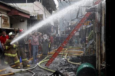 Petugas pemadam kebakaran melakukan pendinginan terhadap bangunan yang terbakar di Jalan Karet Pasar Baru, Karet Tengsin, Jakarta Pusat, Sabtu (31/7/2021).