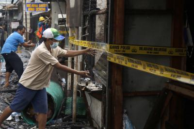 Petugas pemadam kebakaran melakukan pendinginan terhadap bangunan yang terbakar di Jalan Karet Pasar Baru, Karet Tengsin, Jakarta Pusat, Sabtu (31/7/2021).