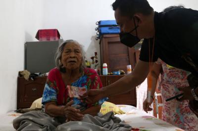 Petugas Pos Indonesia menyalurkan Bantuan Sosial Tunai (BST) kepada lansia di Kedung Sroko, Surabaya, Jawa Timur, Senin (2/8/2021).