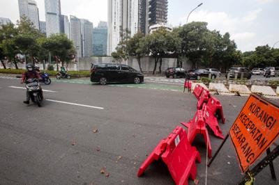 Pengendara sepeda motor menerobos penyekatan di Jalan Jendral Sudirman, Senayan, Jakarta Pusat, Senin (2/8/2021).