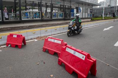 Pengendara sepeda motor menerobos penyekatan di Jalan Jendral Sudirman, Senayan, Jakarta Pusat, Senin (2/8/2021).
