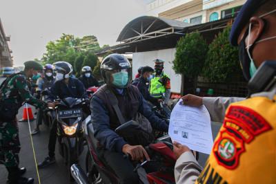Petugas melakukan pemeriksaan Surat Tanda Registrasi Pekerja kepada pengendara yang melewati penyekatan di Pos Lampiri, Kalimalang, Senin (2/8/2021).