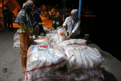 Warga membantu bongkar muat beras bantuan sosial yang tiba di Dermaga Pelabuhan Pulau Panggang, Kepulauan Seribu Utara, Provinsi DKI Jakarta, Selasa (3/8/2021).
