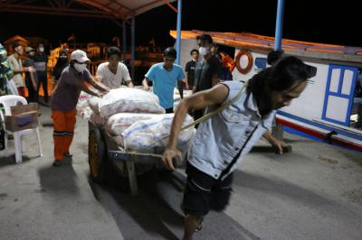 Warga membantu bongkar muat beras bantuan sosial yang tiba di Dermaga Pelabuhan Pulau Panggang, Kepulauan Seribu Utara, Provinsi DKI Jakarta, Selasa (3/8/2021).
