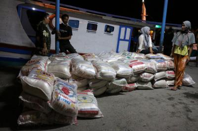 Warga membantu bongkar muat beras bantuan sosial yang tiba di Dermaga Pelabuhan Pulau Panggang, Kepulauan Seribu Utara, Provinsi DKI Jakarta, Selasa (3/8/2021).
