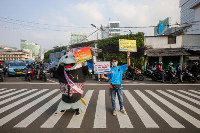 Maskot Hari Konsumen Nasional (HARKONAS) Si Enda melakukan aksi kampanye kepada pengendara yang melintas di kawasan Tugu Tani, Jakarta Pusat, Selasa (3/8/2021).