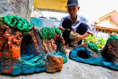 Bang lani (55) membuat miniatur hiasan untuk akuarium di rumahnya, Jalan Adam, Rawa Belong, Jakarta Barat, Selasa (3/8/2021).