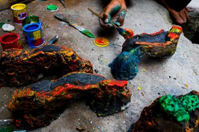 Bang lani (55) membuat miniatur hiasan untuk akuarium di rumahnya, Jalan Adam, Rawa Belong, Jakarta Barat, Selasa (3/8/2021).