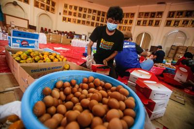 Petugas menyiapkan makanan di dapur umum Kementerian Sosial di Gedung Konvensi, Taman Makam Pahlawan Nasional Utama Kalibata, Jakarta Selatan, Kamis (5/8/2021).