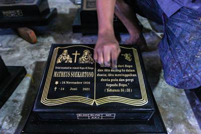 Pekerja saat membuat ukiran nama di batu nisan marmer secara manual di Kawasan TPU Pondok Rangon, Cipayung, Jakarta Timur, Jumat (6/8/2021).