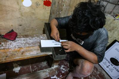 Pekerja saat membuat ukiran nama di batu nisan marmer secara manual di Kawasan TPU Pondok Rangon, Cipayung, Jakarta Timur, Jumat (6/8/2021).
