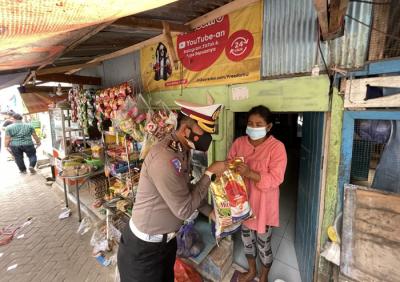 Petugas kepolisian Direktorat Lalulintas Polda Sulsel membagikan paket bantuan sembako pada warga pulau Lae Lae, Makassar, Jumat (6/8/2021).