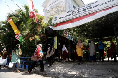 Sejumlah siswa dan walimurid meletakkan donasi berupa kebutuhan pokok di depan gerbang sekolah SD Negeri 1 Airlangga, Surabaya, Jawa Timur, Jumat (6/8/2021).