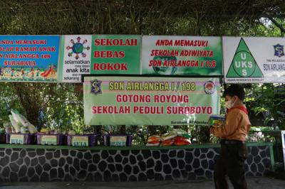 Sejumlah siswa dan walimurid meletakkan donasi berupa kebutuhan pokok di depan gerbang sekolah SD Negeri 1 Airlangga, Surabaya, Jawa Timur, Jumat (6/8/2021).