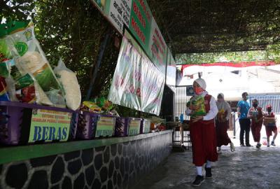 Sejumlah siswa dan walimurid meletakkan donasi berupa kebutuhan pokok di depan gerbang sekolah SD Negeri 1 Airlangga, Surabaya, Jawa Timur, Jumat (6/8/2021).
