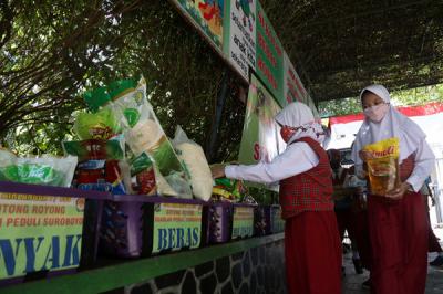 Sejumlah siswa dan walimurid meletakkan donasi berupa kebutuhan pokok di depan gerbang sekolah SD Negeri 1 Airlangga, Surabaya, Jawa Timur, Jumat (6/8/2021).