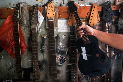 Pekerja menyelesaikan pembuatan gitar di sentra produksi dan reparasi gitar Pak Manto di Pejaten Timur, Pasar Minggu, Sabtu (7/8/2021).