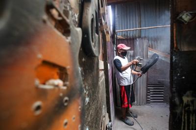 Pekerja menyelesaikan pembuatan gitar di sentra produksi dan reparasi gitar Pak Manto di Pejaten Timur, Pasar Minggu, Sabtu (7/8/2021).