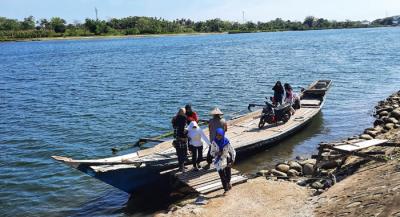 Warga menggunakan perahu penyebrangan di Sungai Jeneberang yang berbatasan langsung Kabupaten Gowa dan Makassar, Minggu (8/8/2021).