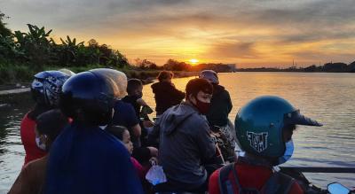 Warga menggunakan perahu penyebrangan di Sungai Jeneberang yang berbatasan langsung Kabupaten Gowa dan Makassar, Minggu (8/8/2021).