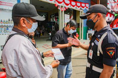 Pengunjung menunjukan sertifikat bukti telah melakukan vaksin kepada petugas sebelum masuk ke Gedung Pasar Jatinegara, Jakarta Timur, Senin (9/8/2021).