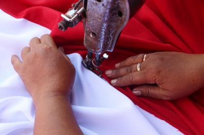 Perajin menjahit Bendera Merah Putih di kampung perajin bendera kawasan Darmo Kali, Surabaya, Jawa Timur, Senin (9/8/2021).