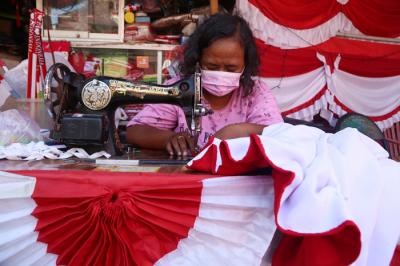 Perajin menjahit Bendera Merah Putih di kampung perajin bendera kawasan Darmo Kali, Surabaya, Jawa Timur, Senin (9/8/2021).