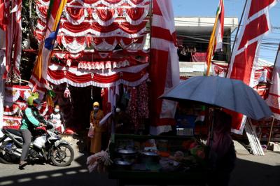 Perajin menjahit Bendera Merah Putih di kampung perajin bendera kawasan Darmo Kali, Surabaya, Jawa Timur, Senin (9/8/2021).