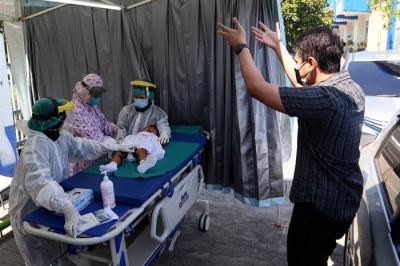 Dokter Spesialis Anak dr. Dini Adityarini memberikan vaksin pada anak ketika melayani vaksinasi secara drive thru di RS Kendangsari Merr, Selasa (10/8/2021).