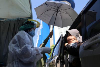 Dokter Spesialis Anak dr. Dini Adityarini memberikan vaksin pada anak ketika melayani vaksinasi secara drive thru di RS Kendangsari Merr, Selasa (10/8/2021).