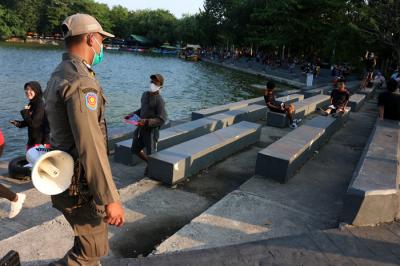 Petugas Satpol PP berkeliling di kawasan danau Sunter, Jakarta, Rabu (11/8/2021).