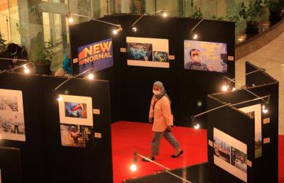 Pengunjung melihat foto yang dipamerkan dalam pameran foto jurnalistik Indonesia Tangguh Indonesia Tumbuh di Mal Central Park, Jakarta, Rabu (11/8/2021).