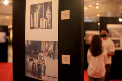 Pengunjung melihat foto yang dipamerkan dalam pameran foto jurnalistik Indonesia Tangguh Indonesia Tumbuh di Mal Central Park, Jakarta, Rabu (11/8/2021).