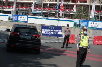 Petugas kepolisian melakukan pengaturan kendaraan saat pelaksanaan pengendalian mobilitas ganjil genap di Jalan MH Thamrin, Jakarta, Kamis (12/8/2021).