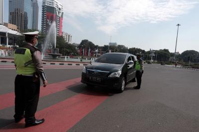 Petugas kepolisian melakukan pengaturan kendaraan saat pelaksanaan pengendalian mobilitas ganjil genap di Jalan MH Thamrin, Jakarta, Kamis (12/8/2021).