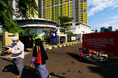 Warga dan nakes saat melintas di kawasan tower RSDC-19 Rumah Susun (Rusun) Pasar Rumput, Jakarta Selatan, Kamis (12/8/2021).