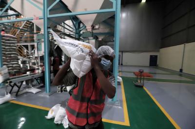 Pekerja mengoperasikan mesin Rice To Rice (RTR) untuk mengisi karung beras bantuan PPKM sebelum didistribusikan ke masyarakat di Jakarta, Jumat (13/8/2021).