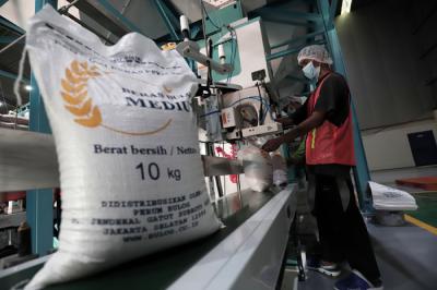 Pekerja mengoperasikan mesin Rice To Rice (RTR) untuk mengisi karung beras bantuan PPKM sebelum didistribusikan ke masyarakat di Jakarta, Jumat (13/8/2021).